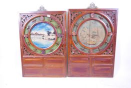 A pair of Chinese carved wood panels with painted roundels of lake and landscape scenes, 25" x 36"