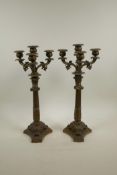 A pair of bronzed spelter three branch candlesticks on Corinthian column and triform bases, 16" high