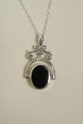 A white metal revolving pendant necklace set with onyx and mother of pearl, 1½" drop