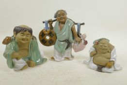 A Chinese, Shiwan style, mud men figure of a traveller with large pi disc and peach carried on a