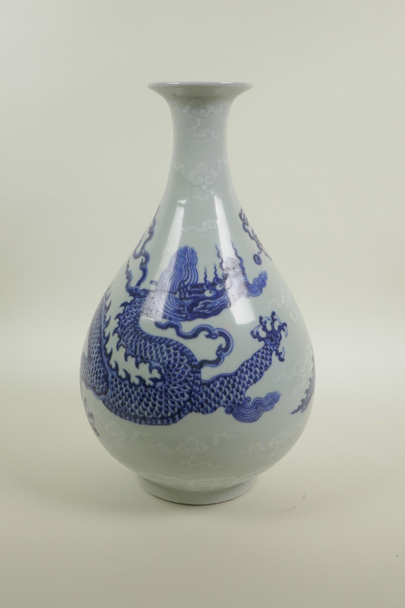 A Chinese blue and white porcelain pear shaped vase decorated in the Ming style depicting dragons