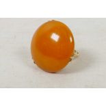 A 9ct gold dress ring set with a large circular amber stone, size 'O'