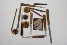 A quantity of tortoiseshell handled manicure tools and a tortoiseshell and silver panel
