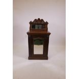 A C19th walnut music cabinet with carved, raised mirrored back, mirrored panel door and reeded