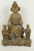 A Chinese gilt bronze figure of a seated deity accompanied by two small acolyte figures, 15" high