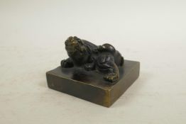 A Chinese filled bronze seal, the surmount in the form of a temple lion, 3" x 3"