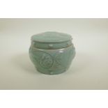 A Chinese celadon crackle glazed porcelain pot and cover with raised underglaze dragon and lotus