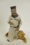 A Chinese, Shiwan style, mud men figure of a man with a tiger at his feet, 12" high