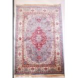 A duck egg blue ground Kashmir carpet with an ornate floral medallion design and an ivory border,