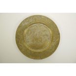 A Chinese bronze circular plaque with chased and engraved decoration of figures in a landscape to