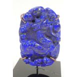 A Chinese carved lapis amulet decorated with exotic beasts, 2½" high