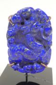 A Chinese carved lapis amulet decorated with exotic beasts, 2½" high