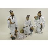 Four Chinese, Shiwan style, mud men figures dressed in white robes, tallest 11½"