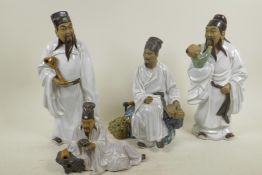 Four Chinese, Shiwan style, mud men figures dressed in white robes, tallest 11½"