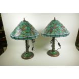 A pair of Tiffany style dragonfly table lamps with bronzed and jewelled decoration on a green