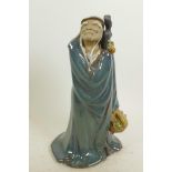 A Chinese, Shiwan style, mud men figure of a travelling sage with basket of fruit, 12" high