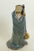 A Chinese, Shiwan style, mud men figure of a travelling sage with basket of fruit, 12" high