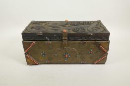 A Sino-Tibetan brass bound carved hardwood casket, with dragon and auspicious symbol decoration, and