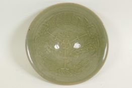 A Chinese porcelain celadon glazed shallow bowl with embossed decoration of birds amongst