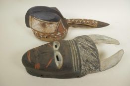 An African painted carved wood horned mask, 14" long, together with a painted carved wood bird's