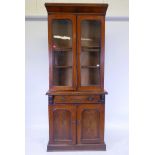 A Victorian inlaid figured mahogany bookcase, the upper section with two glazed arched doors, the