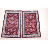 A pair of small Turkish rugs with stylised floral pattern on a red ground, 38" x 24"