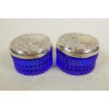 Two blue glass dressing table jars with sterling silver lids embossed with Art Nouveau designs,