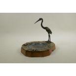 A shaped wood and horn ash tray, decorated with a bronze crane, 9" x 8½", 8½" high