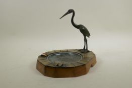 A shaped wood and horn ash tray, decorated with a bronze crane, 9" x 8½", 8½" high