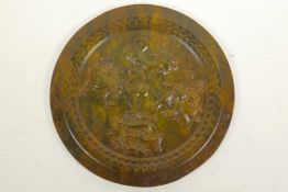 A Chinese carved hardstone ceremonial plate carved with mythical beasts, 8" diameter