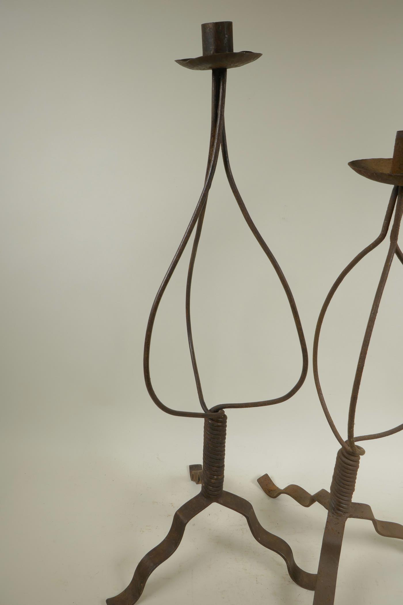 A wrought iron candlestick on tripod base, 24½" high, and another similar - Image 2 of 3