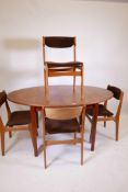 A mid C20th teak dining table with fold out leaf and matching set of four chairs, legs detachable,