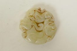 A Chinese mottled white jade pendant with carved dragon and kylin decoration, 2" diameter