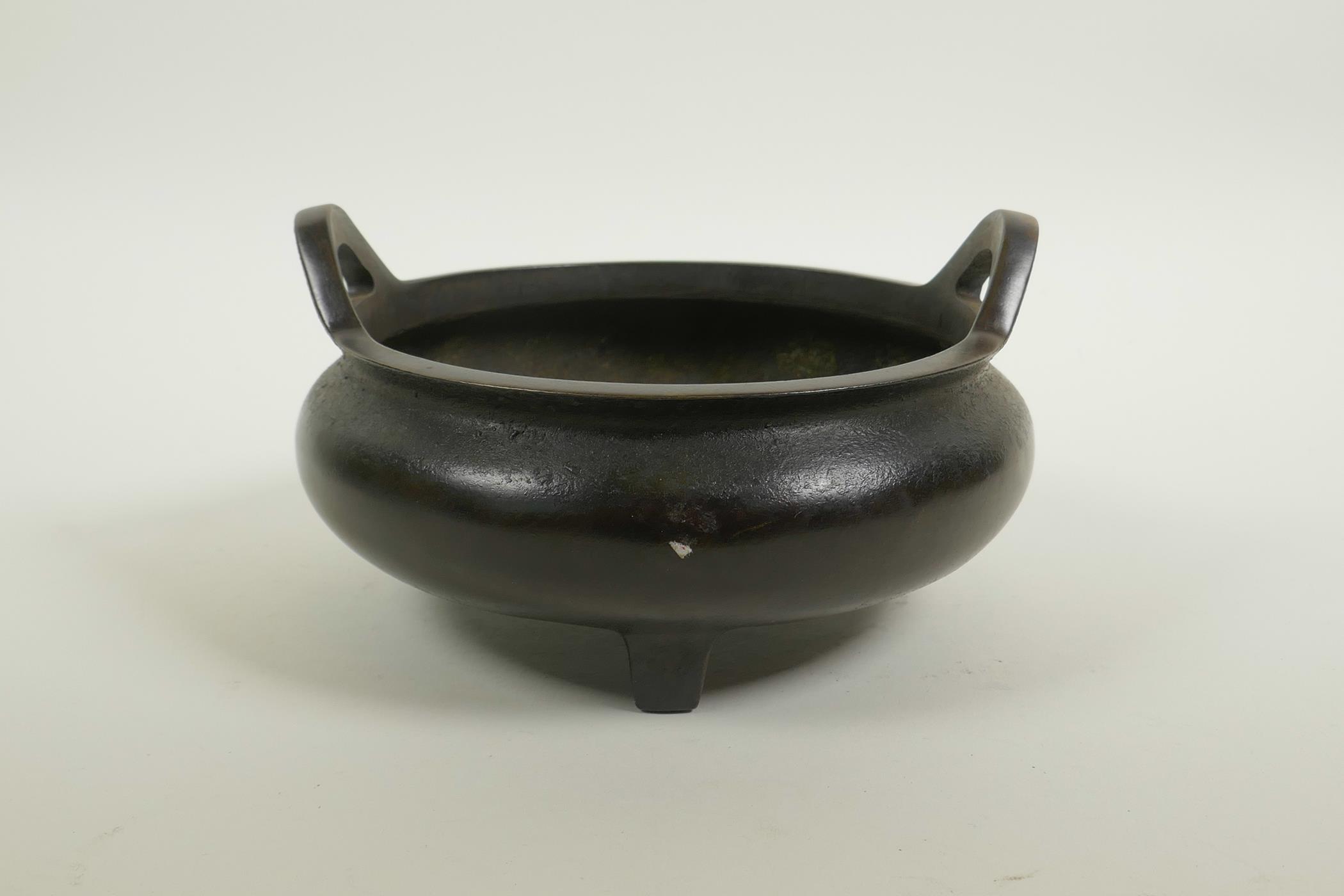 A Chinese bronze censer on tripod supports with phoenix eye handles, impressed seal mark to base, 7"