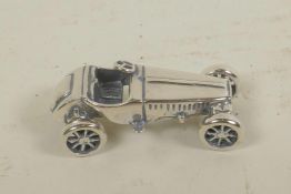 A miniature silver model of a sports car, 1¼" long