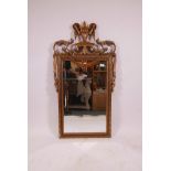 A gilt wall mirror with swag and urn decoration and bevelled glass, 47" x 25"