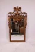 A gilt wall mirror with swag and urn decoration and bevelled glass, 47" x 25"