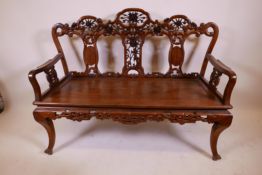 A late C19th/early C20th padauk wood window seat with carved and pierced decoration incorporatinf