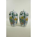 A pair of Chinese famille verte porcelain jar and covers decorated with women, children and a