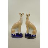 A pair of cast pottery Staffordshire style greyhounds, 8½" high, A/F, chip to ear