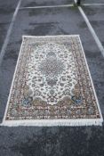 A fine woven ivory ground rug with a multicolour Oriental floral pattern, 59½" x 87"