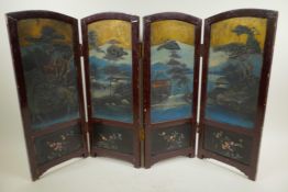 A Chinese four fold table screen painted with embossed lake landscape scenes with buildings and