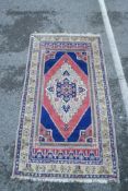 An Oriental pattern carpet with diamond shaped centre medallion on a blue ground within a yellow