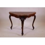 A C19th walnut shaped top fold over card table with carved cabriole legs and scrolled feet, 39" x