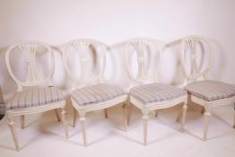 A set of four Scandinavian style chairs, with pierced splats and oval backs, serpentine shaped front