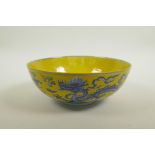 A Chinese Ming style yellow ground porcelain bowl with blue and white dragon decoration, 6 character