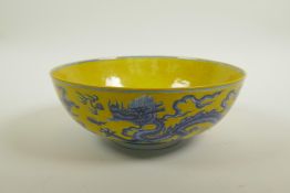 A Chinese Ming style yellow ground porcelain bowl with blue and white dragon decoration, 6 character