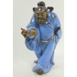 A Chinese, Shiwan style, mud men figure of a warrior with a bat, 12" high