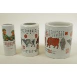 A set of three Chinese porcelain graduated brush pots decorated with calligraphy, cattle and