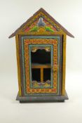 An Indian carved and painted hanging cabinet with a glazed door, 19½" high x 13" wide